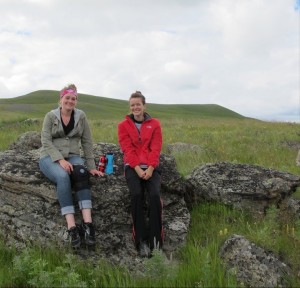 two woman sitting on a rock